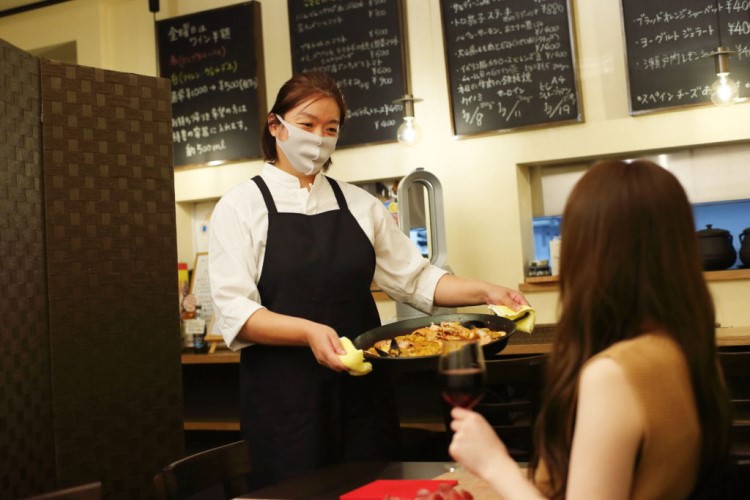 パエリアを提供する店員さん