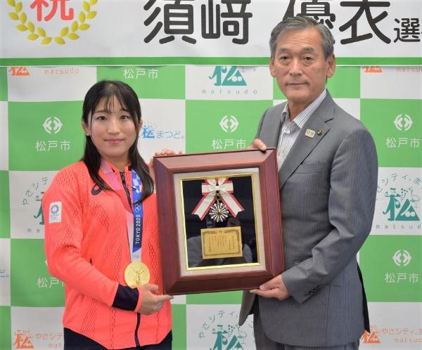 市民栄誉賞の盾を持つ市長と須崎選手
