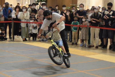 佐々木選手と自転車に乗る小さいお子さんの写真