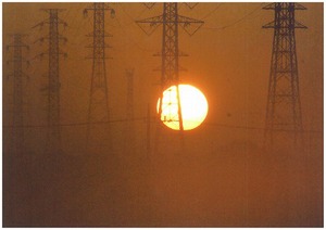 朝もやかかる　鉄塔から透ける日の出の写真