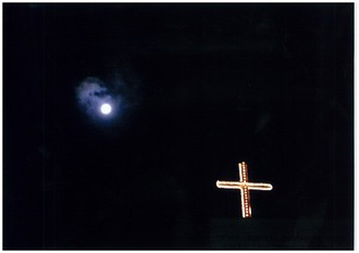 満月と闇に浮かぶ十字架の写真